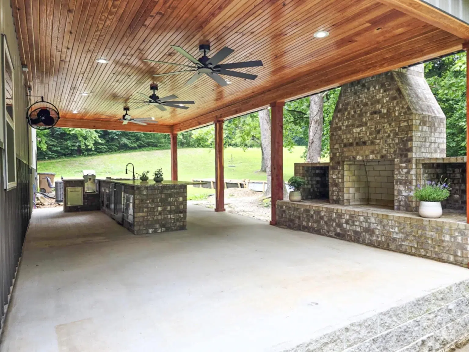 Covered outdoor kitchen with brick worktops and fireplace