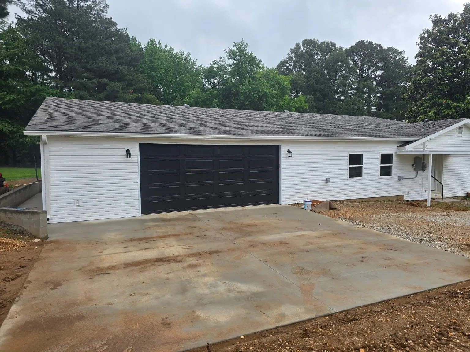 White garage addition with large black garage door